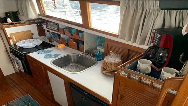 Slide: The Image of Cozy 1985 Roughwater 36 boat kitchen with sink, stove, and coffee maker. - 9