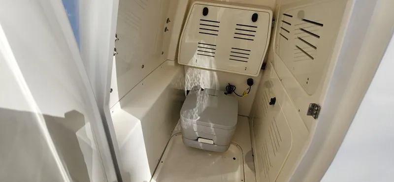 Slide: The Image of 2025 ShearWater 270 SS Open Carolina boat interior with compact marine toilet. - 27