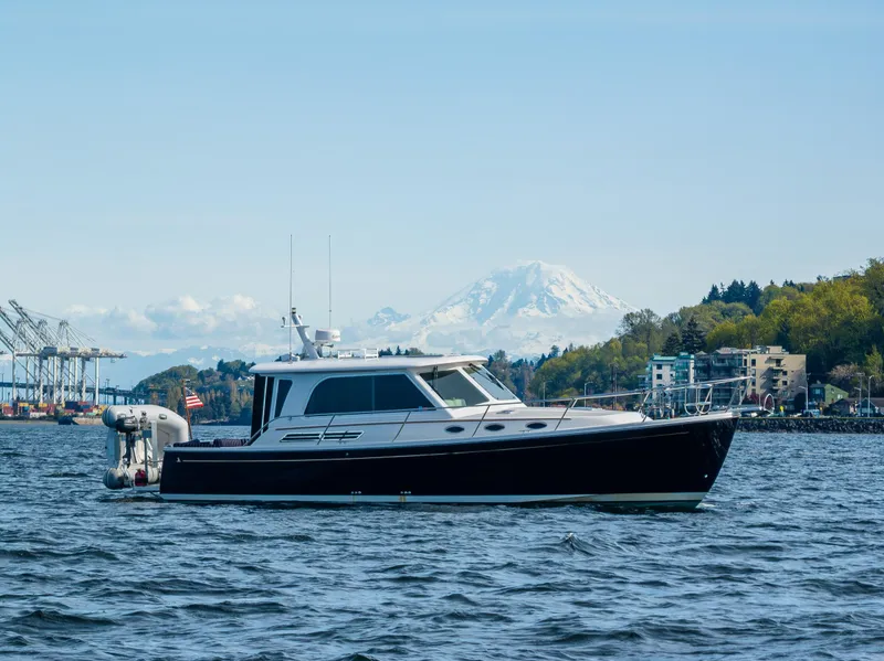Slide: The Image of 2013 Back Cove 37 yacht on water with scenic mountain backdrop. - 0