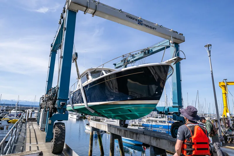 Slide: The Image of 2013 Back Cove 37 boat being lifted at a marina with a travel lift. - 12