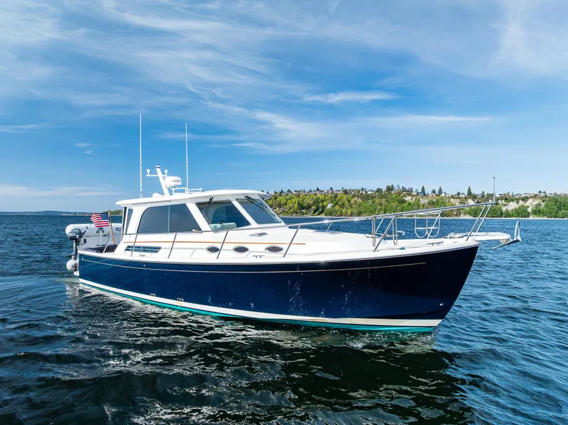 Slide: The Image of 2013 Back Cove 37 boat cruising on open water under a clear blue sky. - 2