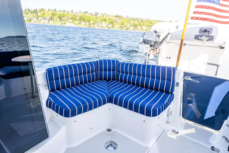 Slide: The Image of 2013 Back Cove 37 boat with blue striped seating on deck, overlooking water. - 34