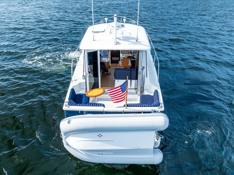 Slide: The Image of 2013 Back Cove 37 boat on water, rear view with American flag. - 9