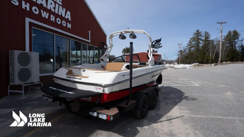 Slide: The Image of 2025 Nautique 200 boat at Long Lake Marina showroom, parked on a trailer. - 8