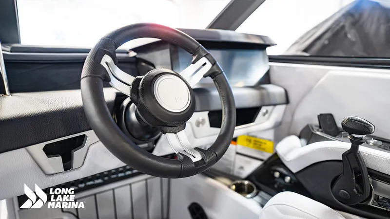 Slide: The Image of 2025 Nautique G23 boat interior with steering wheel and control panel at Long Lake Marina. - 10