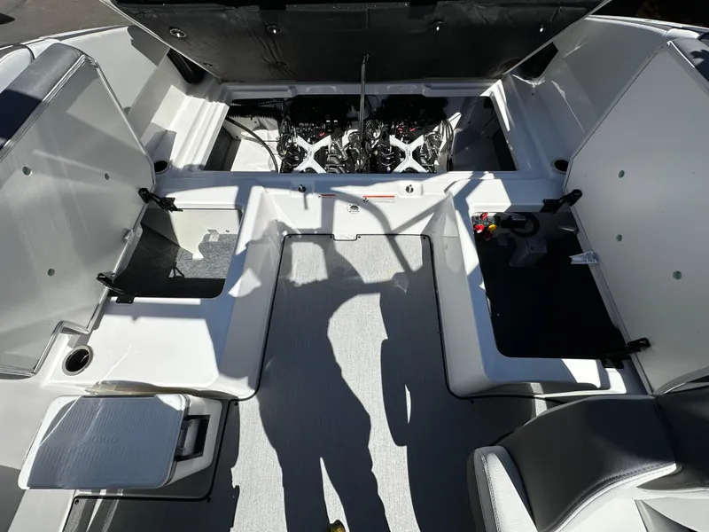Slide: The Image of 2024 Yamaha Boats AR250 interior with open engine compartment, showcasing seating and storage. - 13