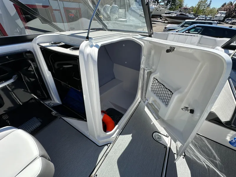 Slide: The Image of 2024 Yamaha Boats AR250 interior storage compartment with open door, showcasing spacious design. - 17
