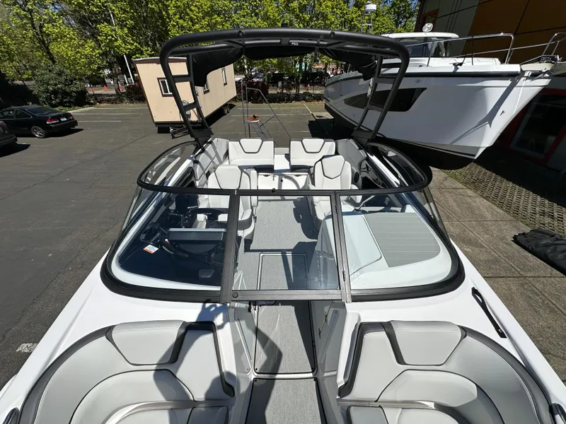 Slide: The Image of 2024 Yamaha Boats AR250 with sleek design and spacious seating in a marina setting. - 22