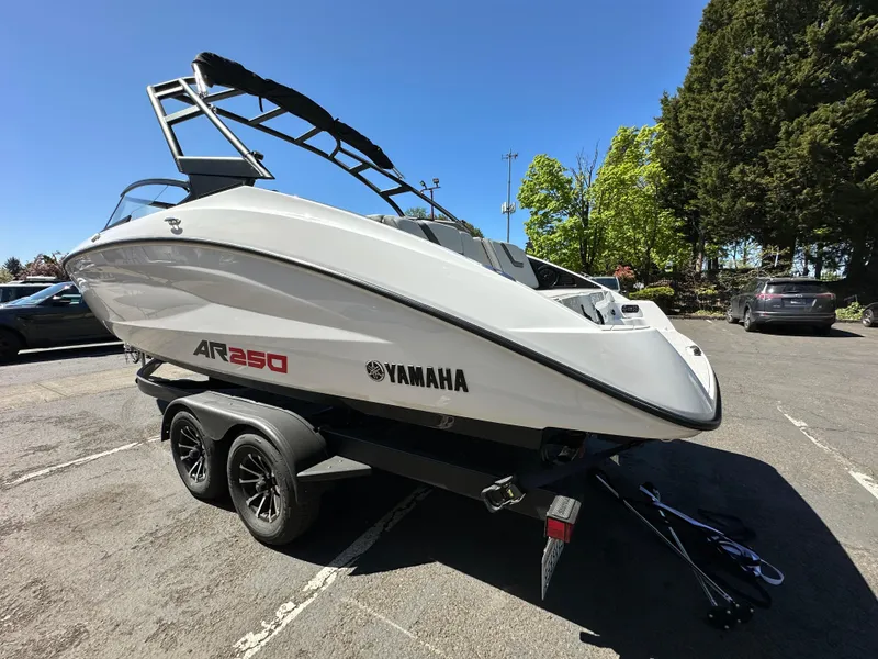 Slide: The Image of 2024 Yamaha AR250 boat on trailer in parking lot, sunny day, trees in background. - 5