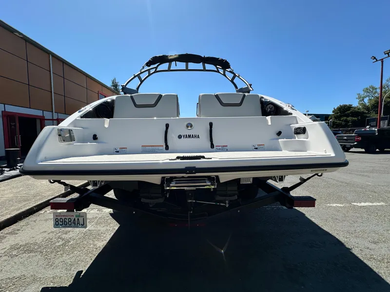 Slide: The Image of 2024 Yamaha Boats AR250, rear view, parked outdoors on a sunny day. - 6