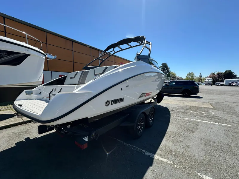Slide: The Image of 2024 Yamaha AR250 boat on trailer in parking lot under clear blue sky. - 8