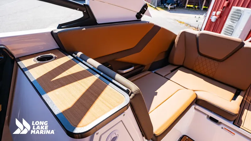 Slide: The Image of 2025 Yamaha Boats 252SD interior with tan seating and wood accents at Long Lake Marina. - 8