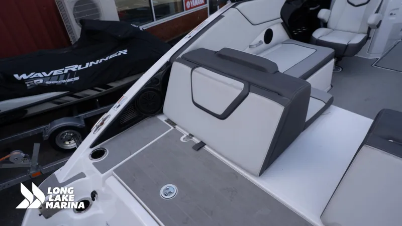 Slide: The Image of 2021 Yamaha Boats AR250 interior with seating and WaveRunner in background at Long Lake Marina. - 13