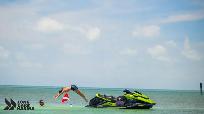 Slide: The Image of 2024 Yamaha FX Cruiser SVHO with Audio on water, person diving nearby, Long Lake Marina logo. - 5