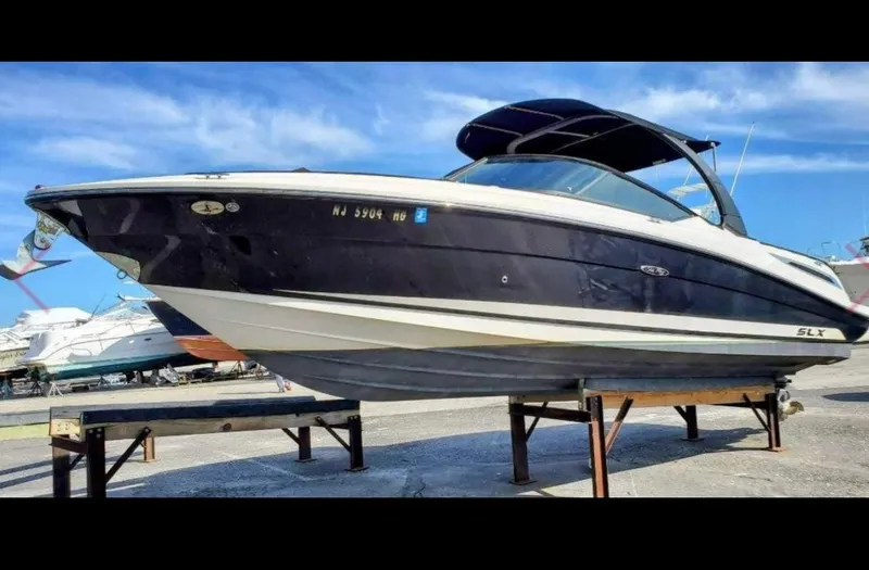 The Image of 2015 Sea Ray 270 SLX boat on stands, under clear blue sky. - 1
