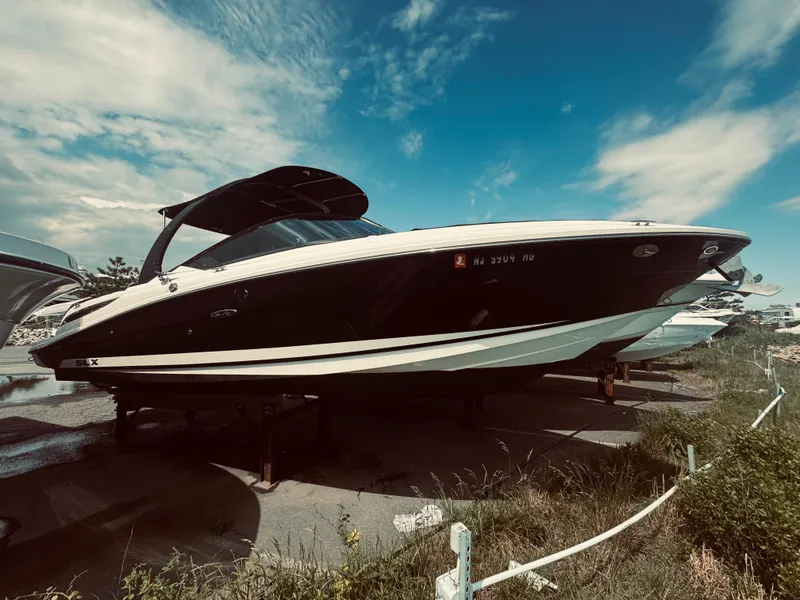 Slide: The Image of 2015 Sea Ray 270 SLX boat on land under a clear blue sky. - 13