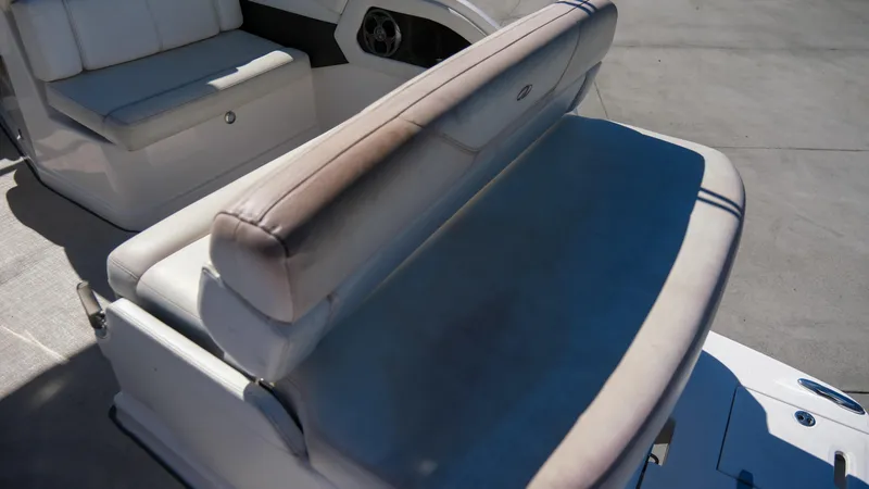 Slide: The Image of 2013 Regal 28 Express boat seating area with cushioned bench and storage. - 12