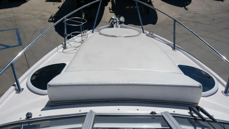 Slide: The Image of 2013 Regal 28 Express boat deck with sunpad and railing in a marina. - 16