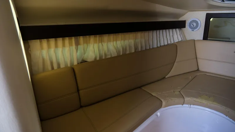 Slide: The Image of Interior cabin of 2013 Regal 28 Express boat with beige seating and curtains. - 19