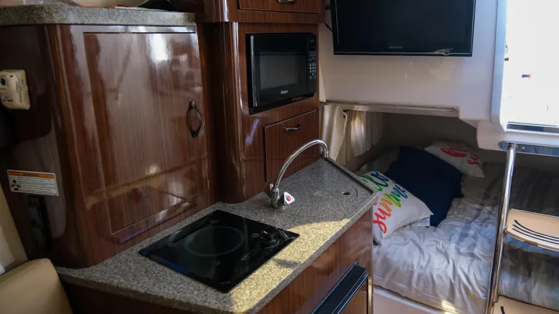 Slide: The Image of Interior of 2013 Regal 28 Express boat with kitchenette and cozy sleeping area. - 20