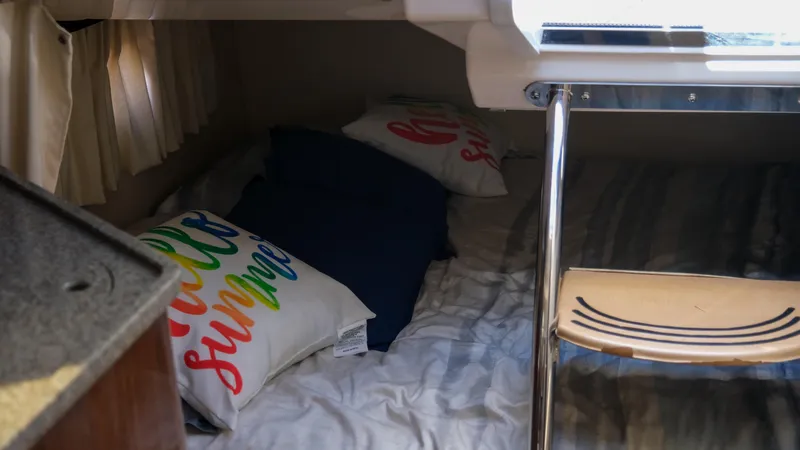 Slide: The Image of Cozy cabin interior of 2013 Regal 28 Express with colorful pillows and bedding. - 21