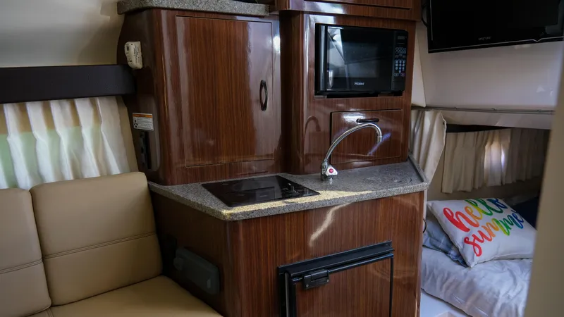 Slide: The Image of Interior of a 2013 Regal 28 Express boat with kitchenette and cozy seating area. - 23