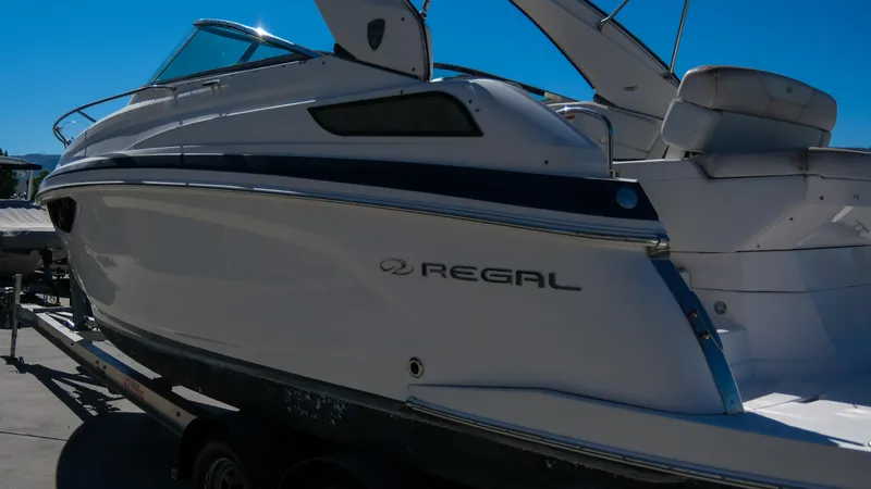 Slide: The Image of 2013 Regal 28 Express boat on trailer, side view under clear blue sky. - 9