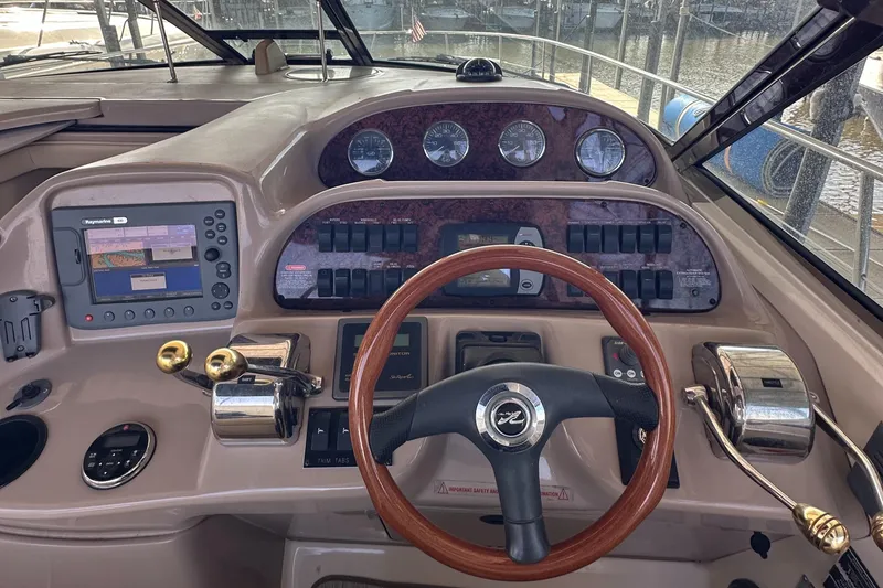 Slide: The Image of 2006 Sea Ray 360 Sundancer helm with wood steering wheel and navigation controls. - 16