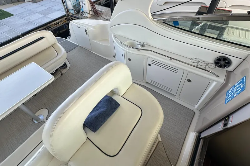 Slide: The Image of 2006 Sea Ray 360 Sundancer interior with white seating and compact kitchenette. - 22