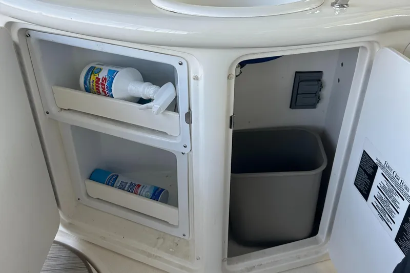 Slide: The Image of Open cabinet on 2006 Sea Ray 360 Sundancer with cleaning supplies and trash bin. - 26