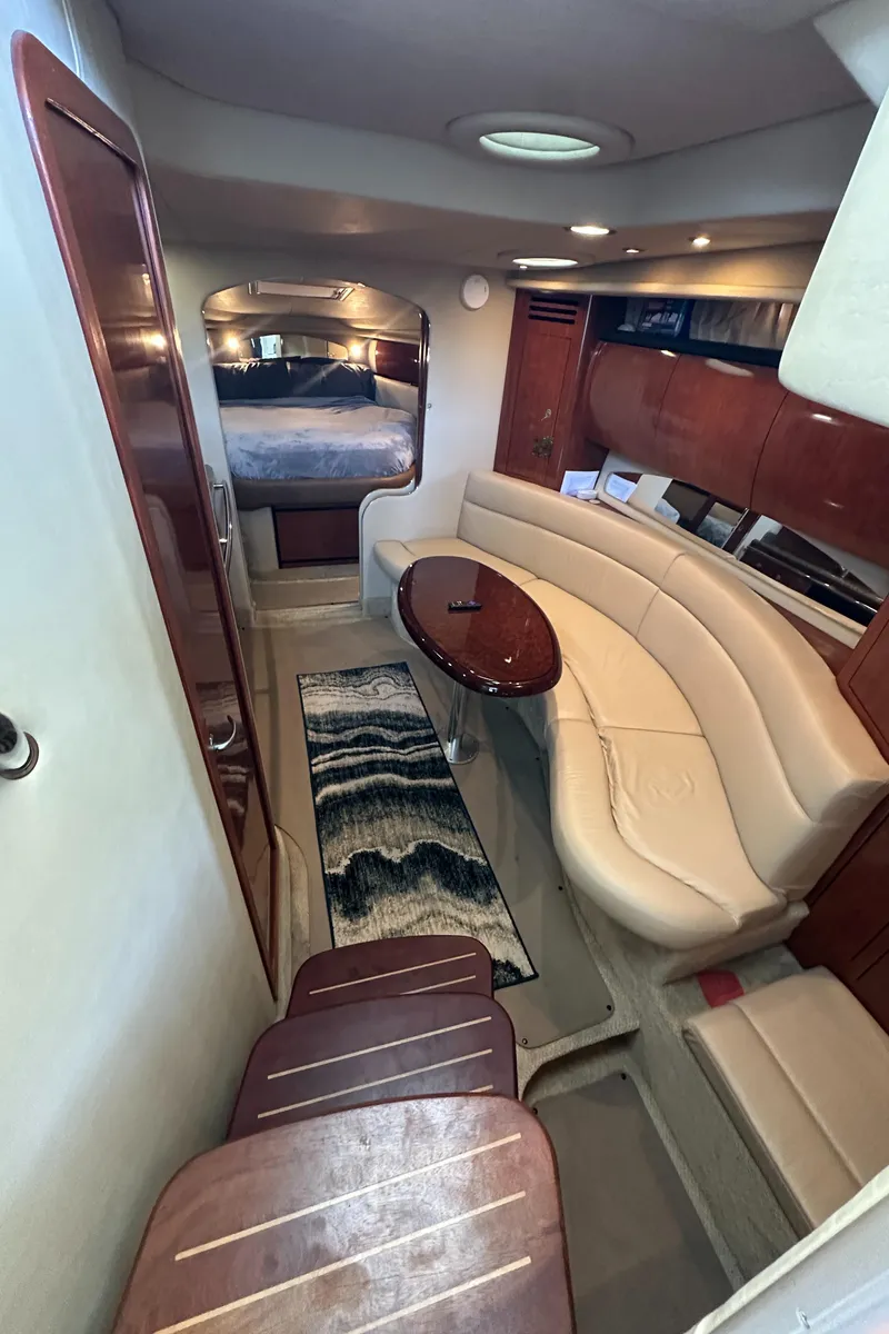 Slide: The Image of 2006 Sea Ray 360 Sundancer interior with curved seating, table, and cozy cabin. - 27