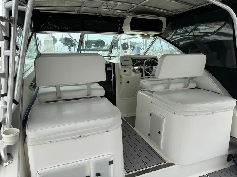 Slide: The Image of 1995 Wellcraft 330 Coastal boat interior with white seating and steering area. - 12