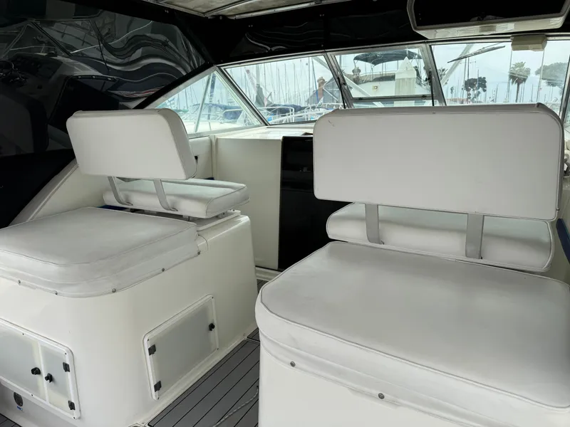 Slide: The Image of 1995 Wellcraft 330 Coastal boat interior with white seating and helm view. - 14