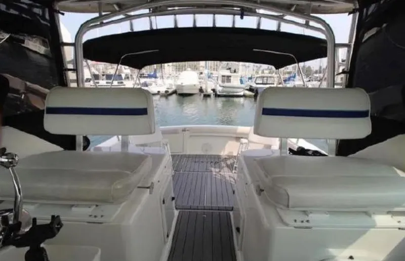 Slide: The Image of 1995 Wellcraft 330 Coastal boat interior with white seating, docked at a marina. - 16