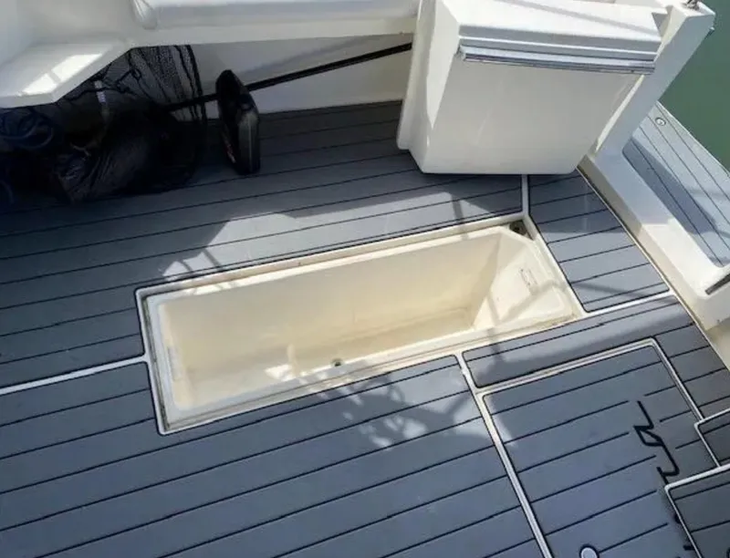 Slide: The Image of 1995 Wellcraft 330 Coastal boat deck with storage compartment, featuring sleek gray flooring. - 18