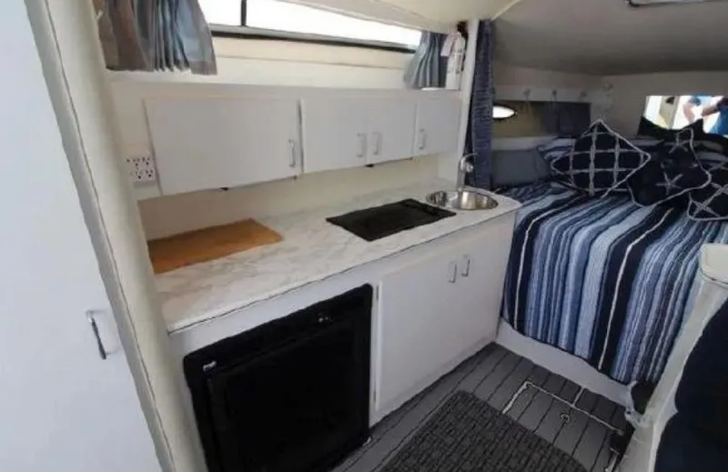 Slide: The Image of 1995 Wellcraft 330 Coastal interior with kitchenette and cozy sleeping area. - 26