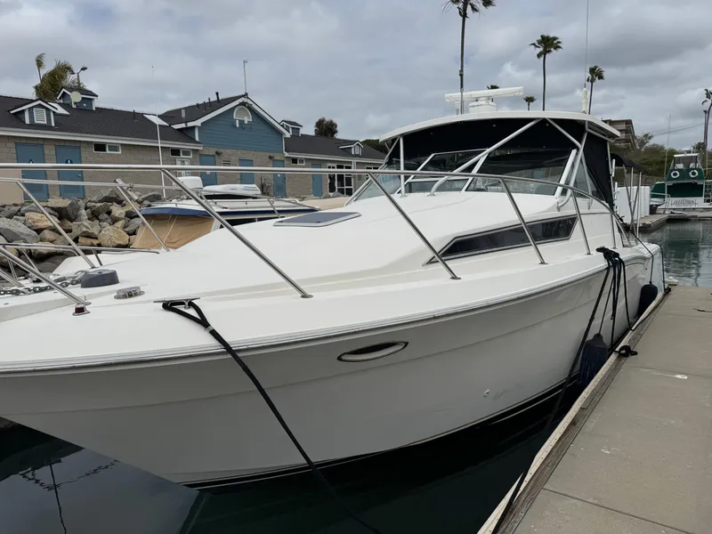 Slide: The Image of 1995 Wellcraft 330 Coastal boat docked at marina, overcast sky, coastal homes in background. - 3