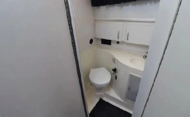 Slide: The Image of 1995 Wellcraft 330 Coastal boat bathroom with white cabinetry and compact design. - 30