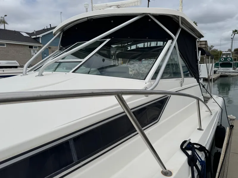 Slide: The Image of 1995 Wellcraft 330 Coastal boat docked, featuring sleek design and sturdy railings. - 4