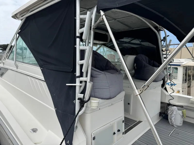 Slide: The Image of 1995 Wellcraft 330 Coastal boat with black canopy and cushioned seating. - 6