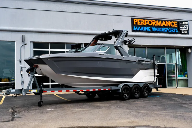 Slide: The Image of 2025 MasterCraft XStar 25 boat on trailer outside Performance Marine Watersports store. - 1