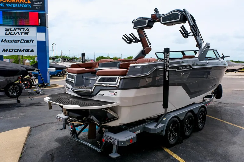 Slide: The Image of 2025 MasterCraft XStar 25 boat on trailer at dealership, showcasing sleek design and modern features. - 11