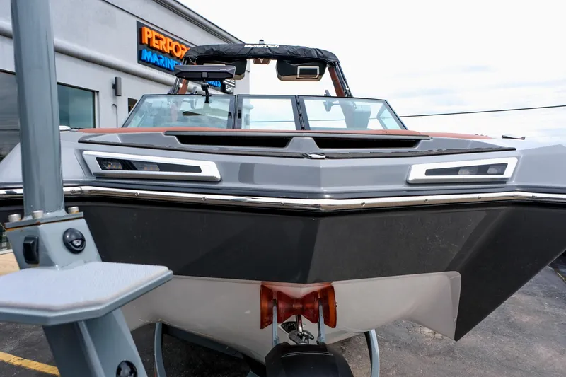 Slide: The Image of 2025 MasterCraft XStar 25 boat at dealership, front view, sleek design, modern features. - 14
