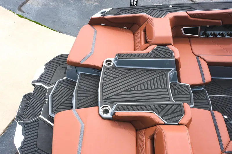 Slide: The Image of 2025 MasterCraft XStar 25 boat interior with brown seating and black geometric flooring. - 19