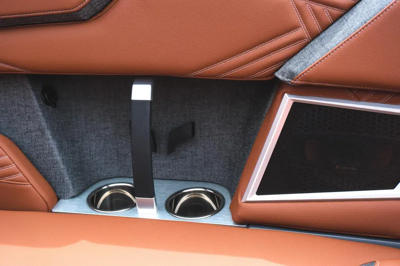 Slide: The Image of 2025 MasterCraft XStar 25 interior with brown leather, cup holders, and speaker detail. - 30