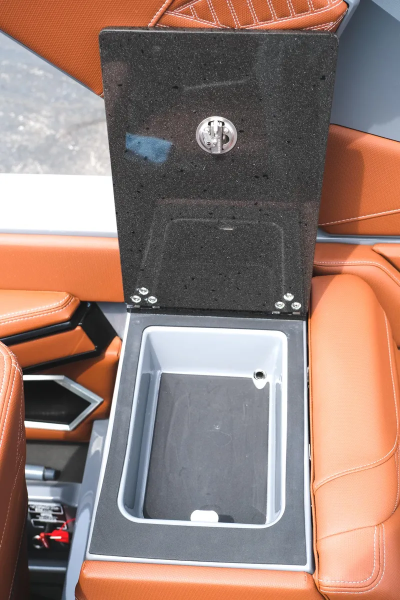 Slide: The Image of 2025 MasterCraft XStar 25 boat interior with open storage compartment and luxurious seating. - 36