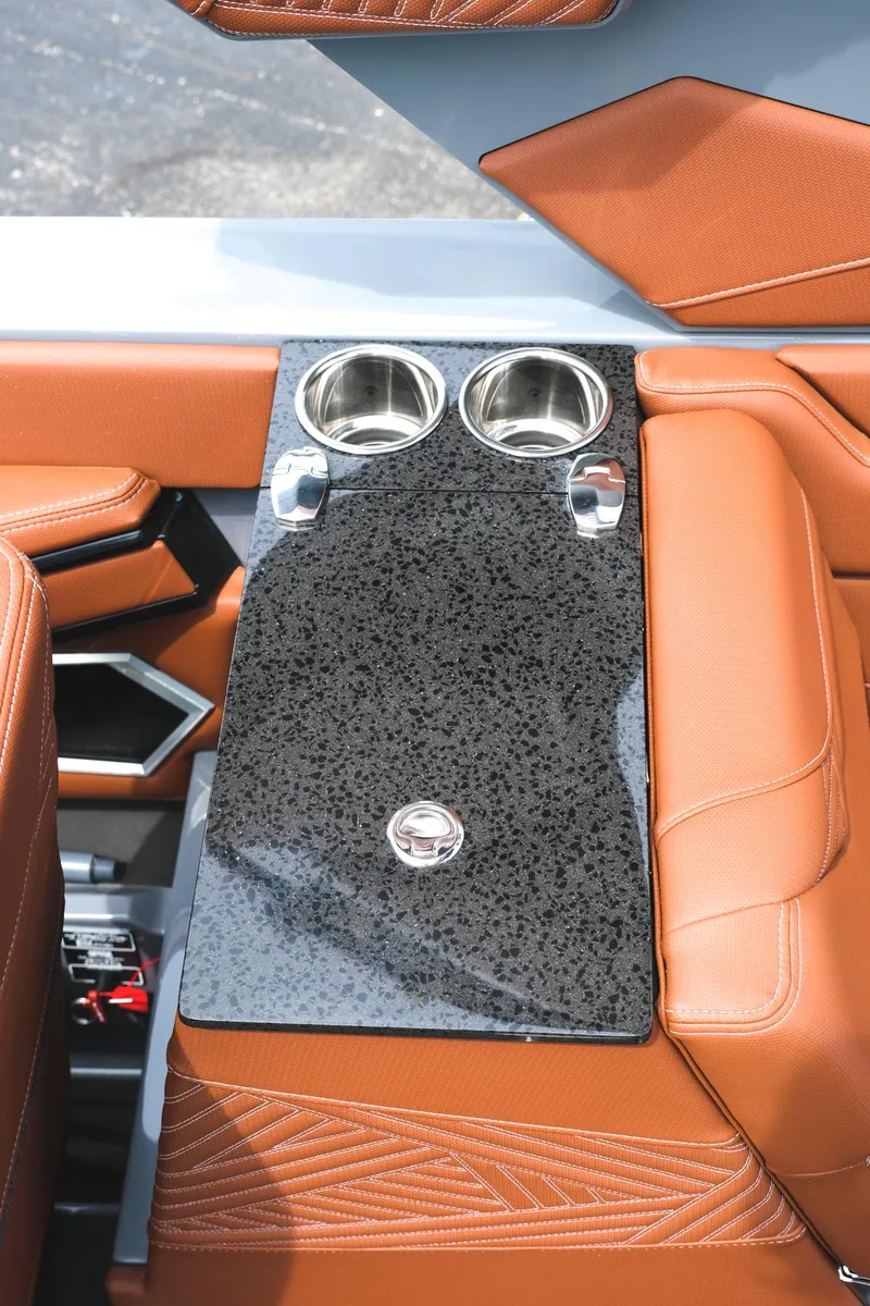 Slide: The Image of 2025 MasterCraft XStar 25 interior with sleek black table and brown leather seating. - 37