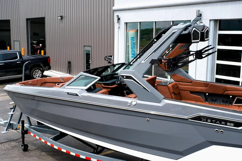 Slide: The Image of 2025 MasterCraft XStar 25 boat with sleek gray design and modern features, parked on a trailer. - 6