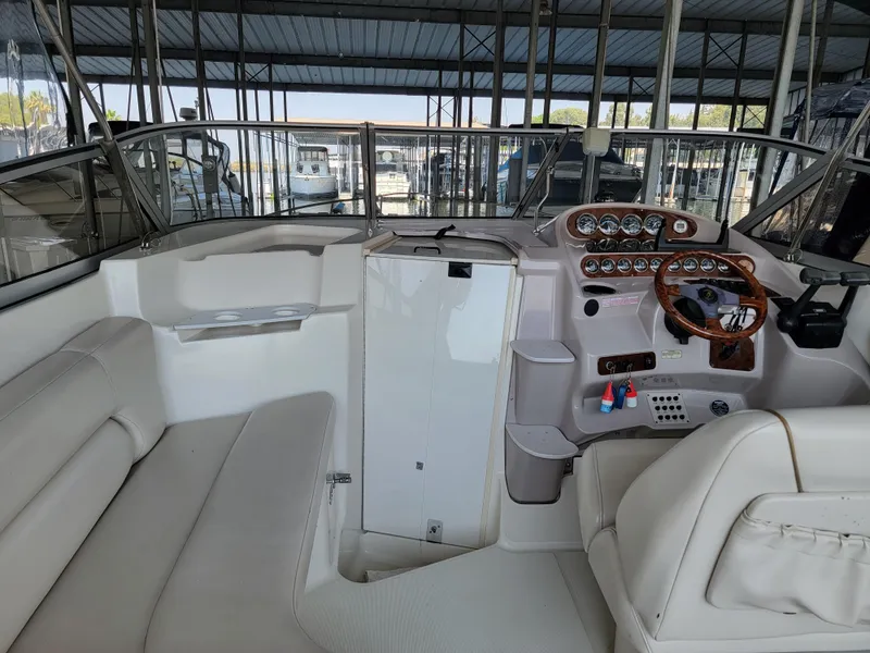 Slide: The Image of Interior view of a 2000 Regal 2860 Commodore boat with white seating and control panel. - 10