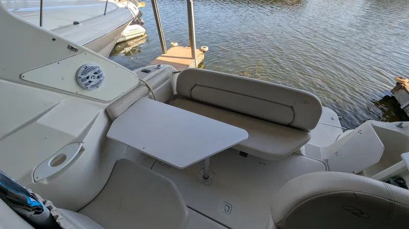 Slide: The Image of 2000 Regal 2860 Commodore boat interior with seating and table by the water. - 15